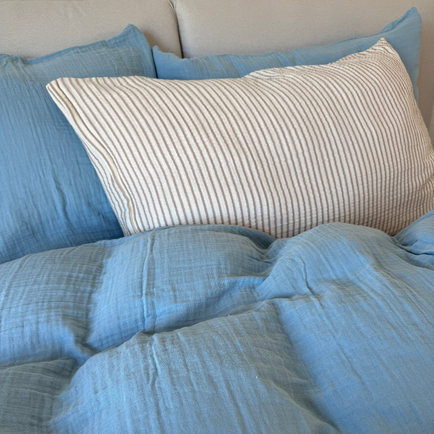 Himmelblaue Musselin Bettwäsche kombiniert mit gestreifter Bettwäsche.